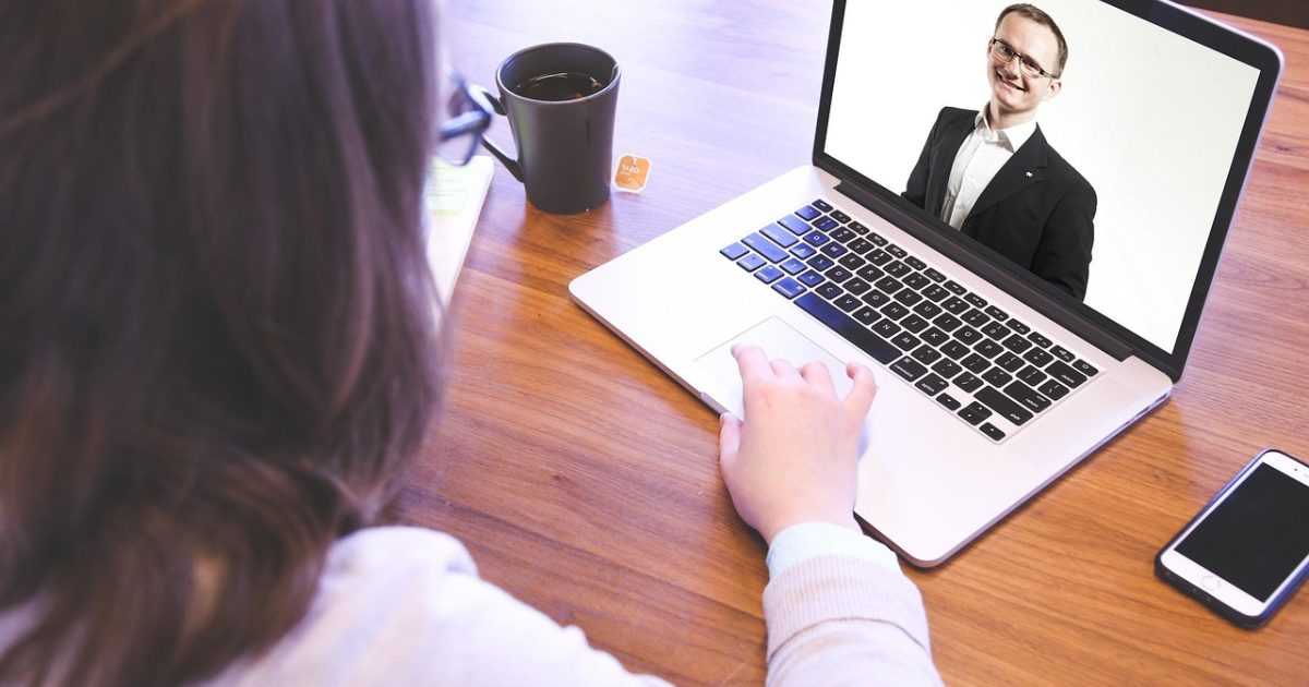 A remote video interview on a laptop, reducing time to hire with AI interviews